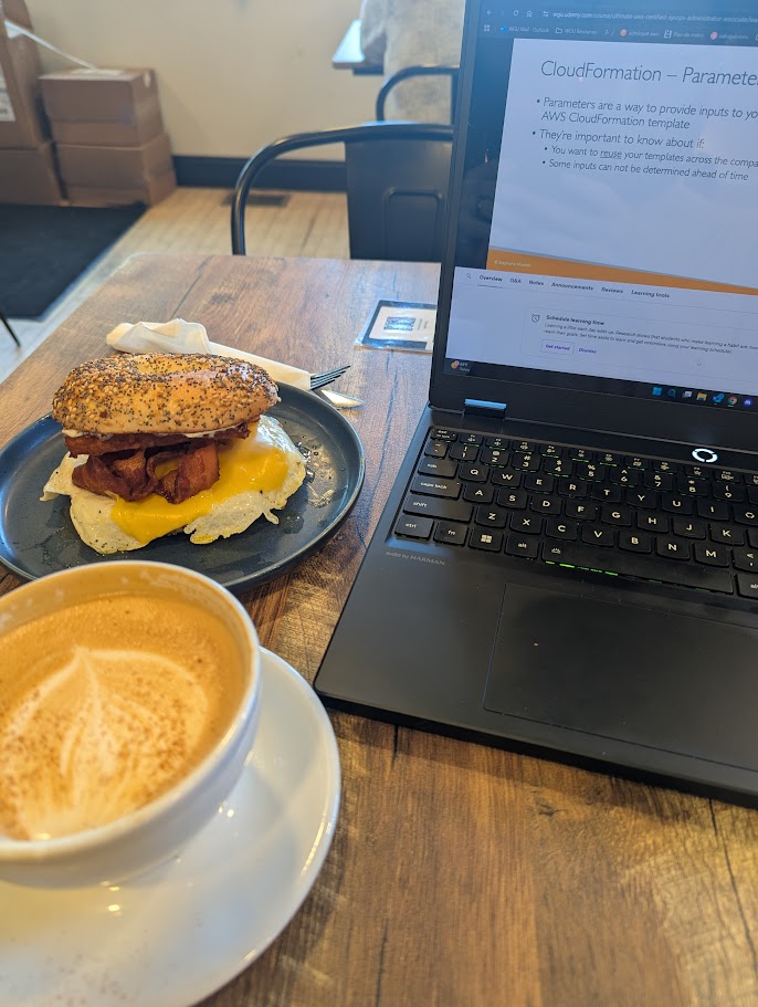 Photo of a breakfast sandwich and fancy coffee drink at a cafe.